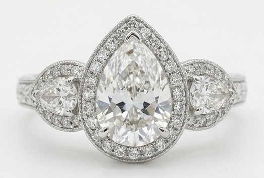 Lab Grown 5.00 Ct Pear Shape Diamond Ring – Vintage Three-Stone Pear Halo – / in 14K White Gold: Beautifully styled, this ring is anchored by a 5.00 carat lab grown Pear Shape center diamond as the focal point. The vintage three-stone pear halo design is paired with White Gold for a sleek, refine