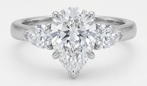 Lab Grown 5.00 Ct Pear Shape Diamond Ring – Classic Three-Stone Pear (Pear Sides) – / in 14K: Graceful and eye-catching, this ring is set with a 5.00 carat lab grown Pear Shape center diamond. White Gold gives the piece a refined, neutral foundation for daily wear or events. The overall style 