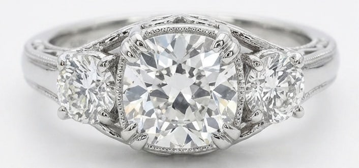 Lab Grown 5.00 Ct Round Brilliant Diamond Ring – Vintage Three-Stone Round with Filigree – / in: Beautifully styled, this ring is anchored by a 5.00 carat lab grown Round Brilliant center diamond as the focal point. The vintage three-stone round with filigree design is paired with White Gold for 