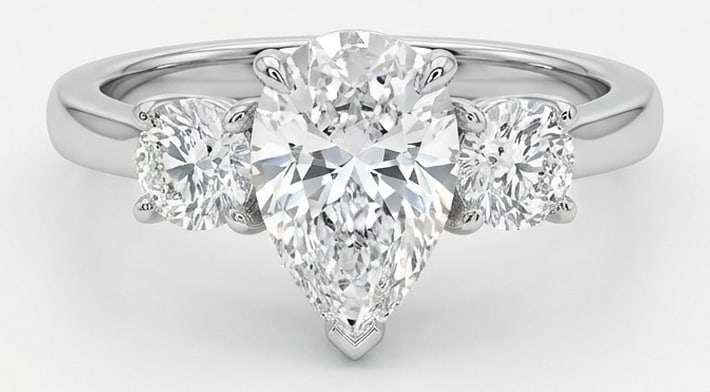Lab Grown 4.00 Ct Pear Shape Diamond Ring – Three-Stone Pear with Round Sides – / in 14K White: Beautifully styled, this ring is anchored by a 4.00 carat lab grown Pear Shape center diamond. Featuring a Three-Stone Pear with Round Sides aesthetic, balancing bold geometry with wearable elegance. 