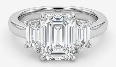 Lab Grown 5.00 Ct Emerald Diamond Ring – Three-stone setting with step-cut trapezoid side stones: Graceful and eye-catching, this ring is set with a 5.00 carat lab grown Emerald center diamond. Set in White Gold, the ring is styled with three-stone setting with step-cut trapezoid side stones detai