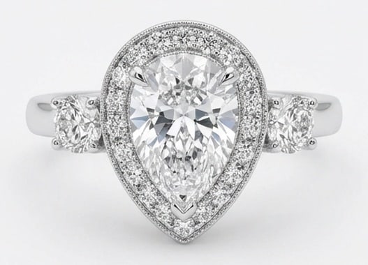 Lab Grown 4.00 Ct Pear Diamond Ring – Pear-shaped halo setting with round side stones and milgrain: Sophisticated and modern, this ring is defined by a 4.00 carat lab grown Pear center diamond as the focal point. The pear-shaped halo setting with round side stones and milgrain rim design is paired w
