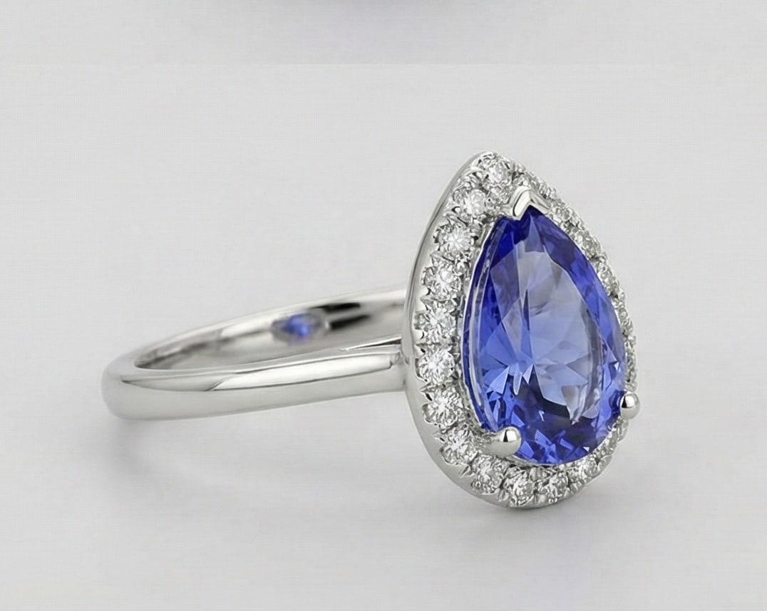 2.0 Ct Pear Natural Tanzanite 14K White Gold Halo Setting with Plain Shank Ring - Certified: This certified fine jewelry piece features a 2.0 carat natural Tanzanite in a Pear cut, crafted in 14K White Gold. The Halo Setting with Plain Shank design highlights the beauty of the natural center 