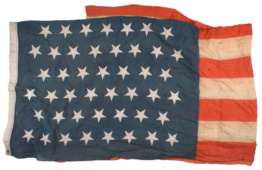 Spanish-American War 45 star flag: K-095 Spanish-American War, 45-star flag. Blue canton with 45 white stars, each separately machine sewn. Red and white horizontal stripes also separately sewn. Age darkened white border shows traces o