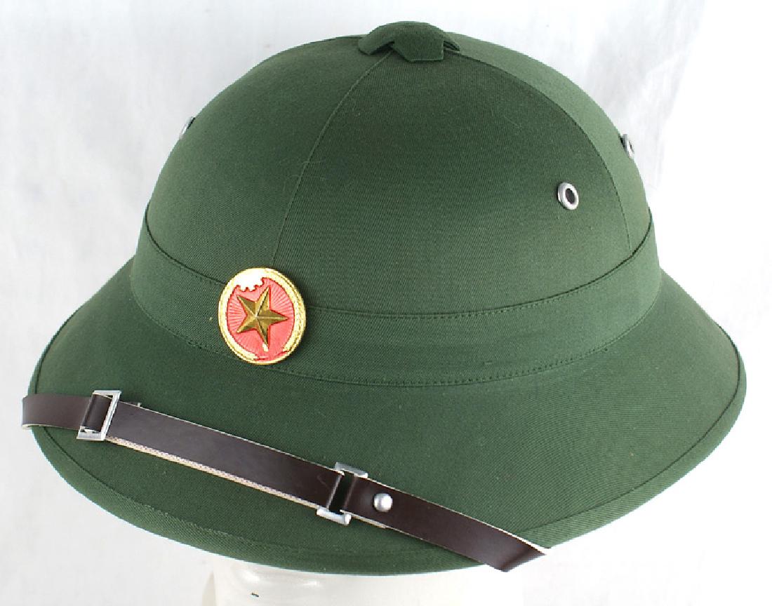Chinese made North Vietnamese pith helmet: E-053 Chinese made North Vietnamese pith helmet. Green cloth covered fiber body with a gilt star insignia and leather chinstrap. Cloth sweatband. New condition. I