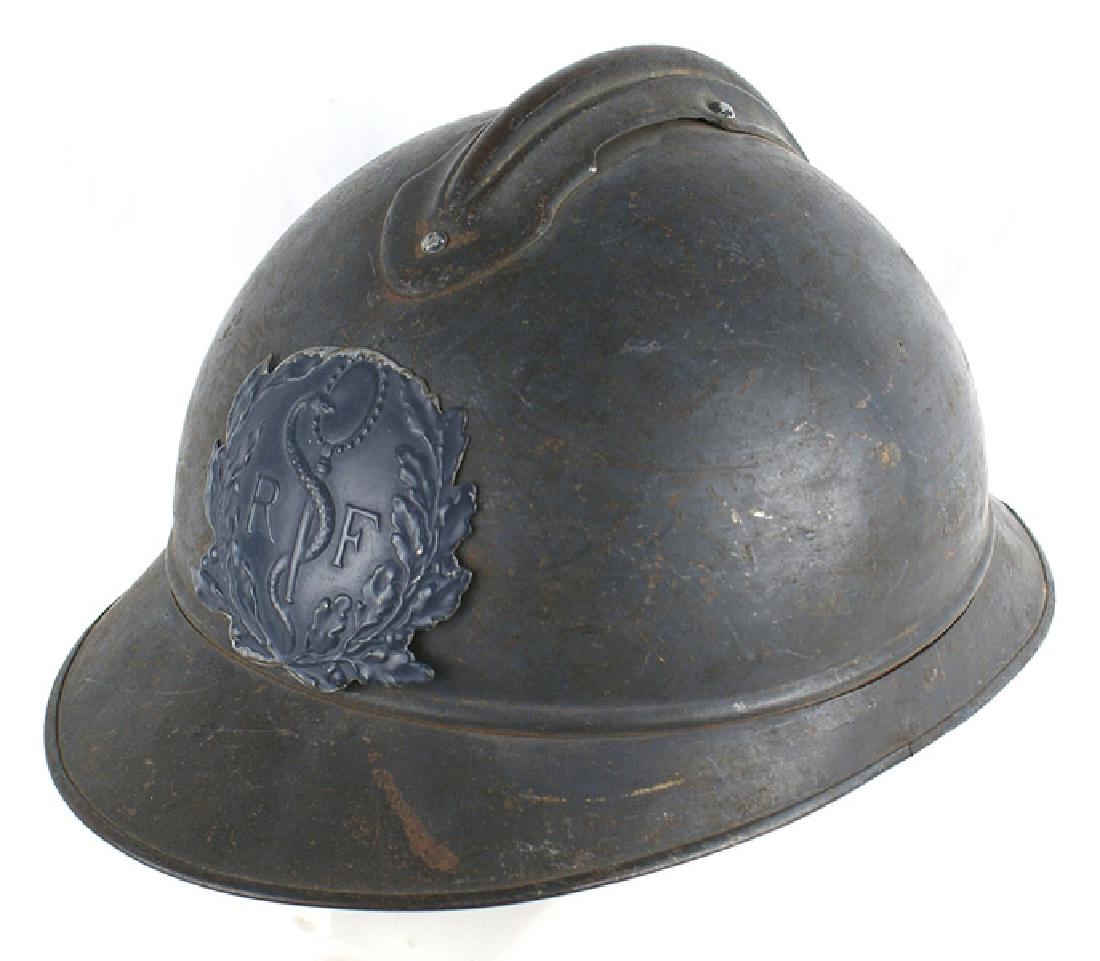 French WWI Medical Adrian style helmet: E-058 French WWI Medical Adrian-style helmet. Blue-gray skull with short front and back visor and a ribbed comb. Finish shows scratches, two small dents and field wear. The darker blue Medical helmet 