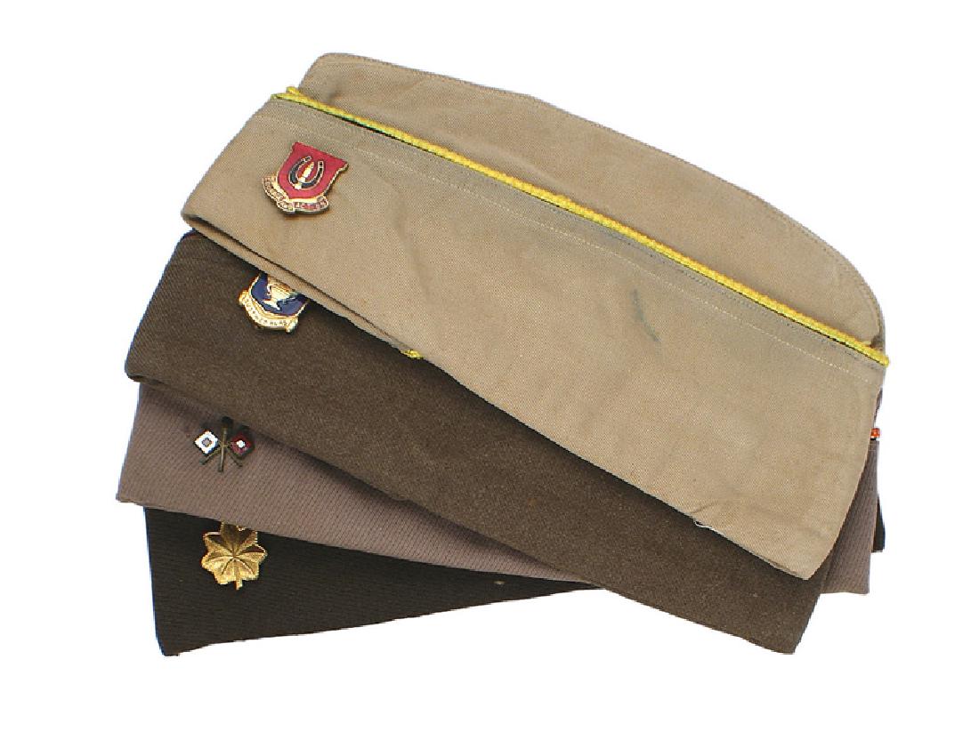 Lot of 8 U.S. WWII overseas caps: E-103 Lot of 8 U.S. WWII o'seas caps: (1) Cavalry. Tan with yellow cord piping. Enameled "COURAGE AND ACTION" D.I. (2) Pair of "SUSTINED ALAS" D.I.'s. Lining is numbered "D-4667". (3) Signal Corps Off