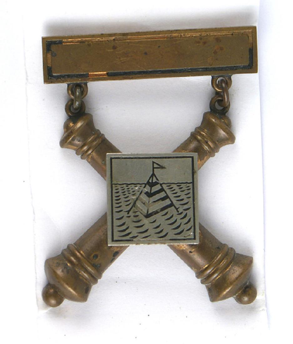 U.S. Span Am Coastal Artillery Badge: B-176 U.S. Span-Am period Coastal Artillery Badge. Silver plaque (ocean with a flagged buoy, on crossed cannons) with a pin-back suspension bar. Marked "103 CO COAST ART NO 75". II