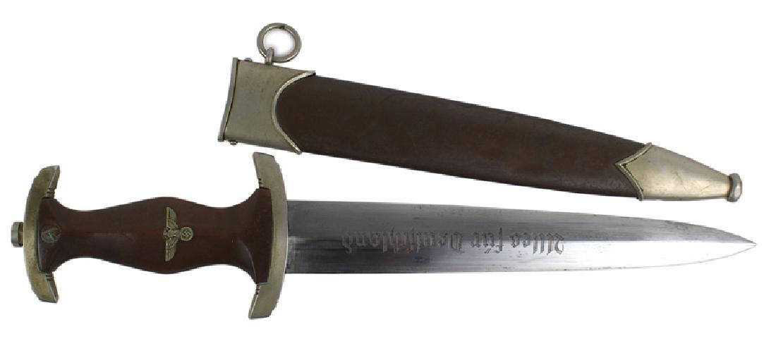 German WWII SA dagger: D-004 German WWII SA Dagger. Brown rosewood grip with a silver insert eagle/swastika and SA insignia. Aged patina on the top and lower crossguard (which is marked "Wm"). 9 3/4" double edged blade with