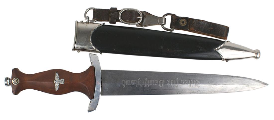 German WWII NSKK EM dagger: D-010 German WWII NSKK EM dagger. Rosewood grip (1/2" separation at the reverse top) with an enameled "SA" roundel and silvered eagle/swastika in grip. Age toned lower crossguard, top one is missing. 