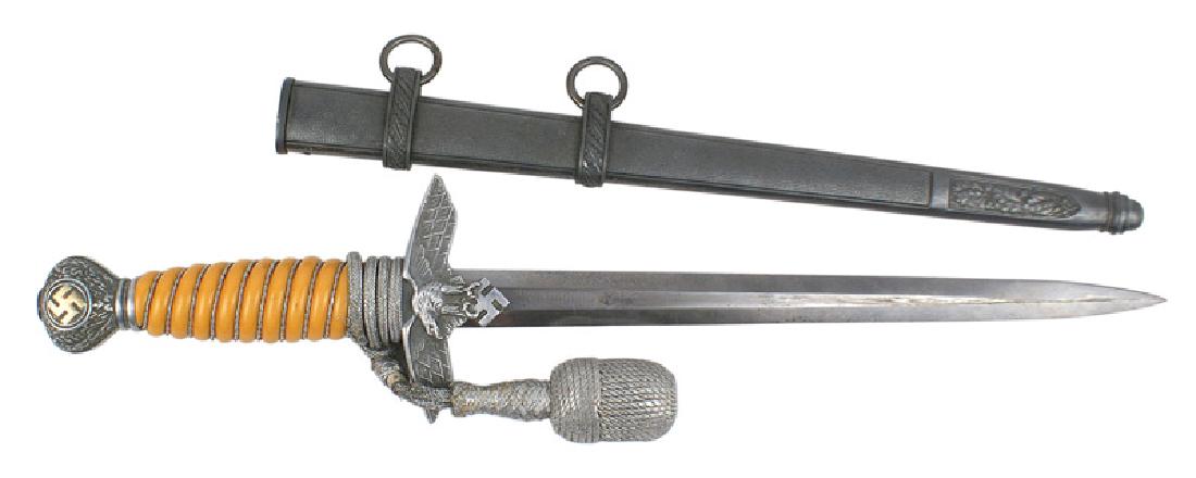German WWII Luftwaffe dagger 2nd Model: D-025 German WWII Luftwaffe Officer's 2nd Model dagger. Oak leaf decorated aluminum pommel with an age toned gold swastika. Flying eagle/swastika crossguard. Silver wire wrapped light orange grip. 10 