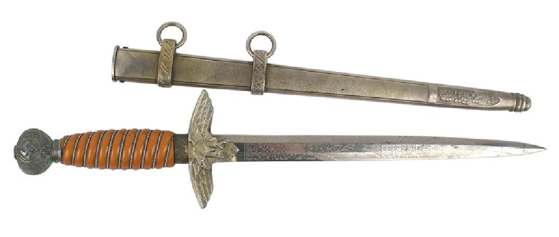 German WWII Luftwaffe dagger 2nd Model: D-027 German WWII Luftwaffe Officer 2nd Model dagger. Round pommel bearing a swastika within an oak leaf wreath. Eagle/swastika crossguard. Deep orange bakelite grip with silver bullion wire wrapping.