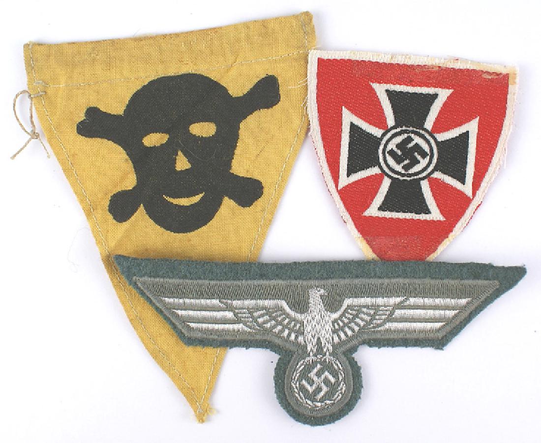 Lot of 3 German WWII cloth Army Loyalty League: H-050 Lot of 3 German WWII cloth items: (1) Army. Flat silver wire breast eagle/swastika on gray-green machine sewn to an OD cloth backing. (2) Loyalty League sleeve shield. Bevo-embroidered black swa