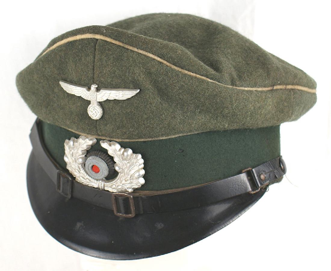 German WWII Army Infantry EM NCO peaked cap: E-076 German WWII Army Infantry EM/NCO peaked cap. Metal eagle/swastika and rosette/oak leaf wreath. Black Vulcan visor. Leather chinstrap. High front peak. Worn and soiled leather sweatband and liner