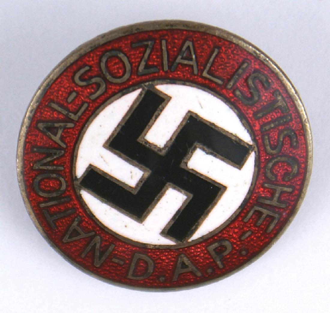 German WWII NSDAP members lapel pin: B-102 German WWII N.S.D.A.P. members lapel pin. Enameled black swastika on a white disc center with "NATIONAL - SOCIALISTISCHE - D.A.P." on a red border. Pin-back is marked "RZM" and "M1/34". II