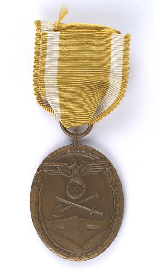German WWII Westwall Medal: B-205 German WWII Westwall Medal. Large eagle/swastika, crossed shovel/sword above a bunker. Awarded to all personnel who helped construct Germany's West Wall Fortifications. With ribbon. I