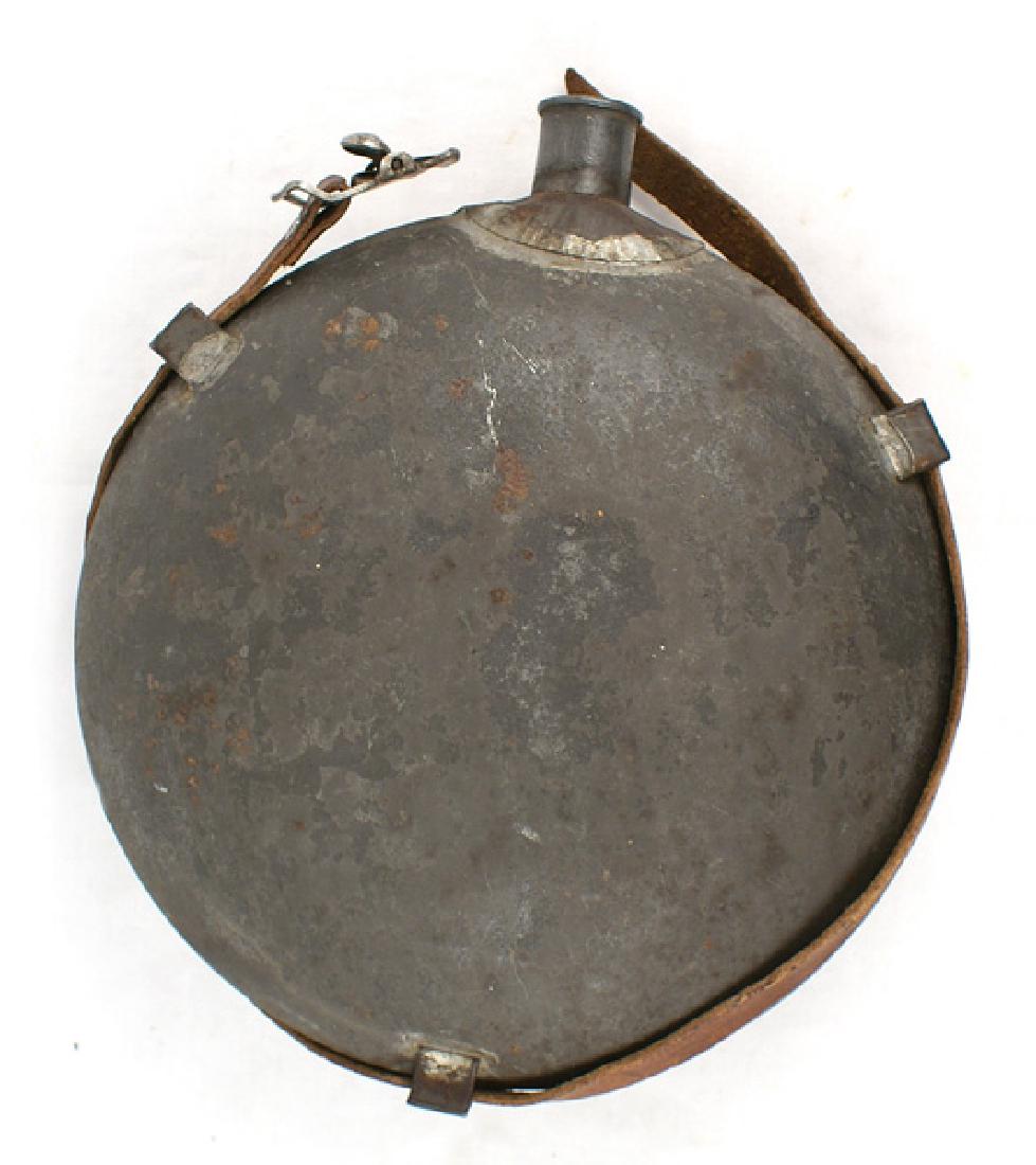 U.S. Civil War canteen: K-007 U.S. Civil War canteen. Round tin body with three soldered - on metal sleeves - holding a post Civil War leather strap. 7/8" peuter neck is etched "Drich IRIE". No cover. II