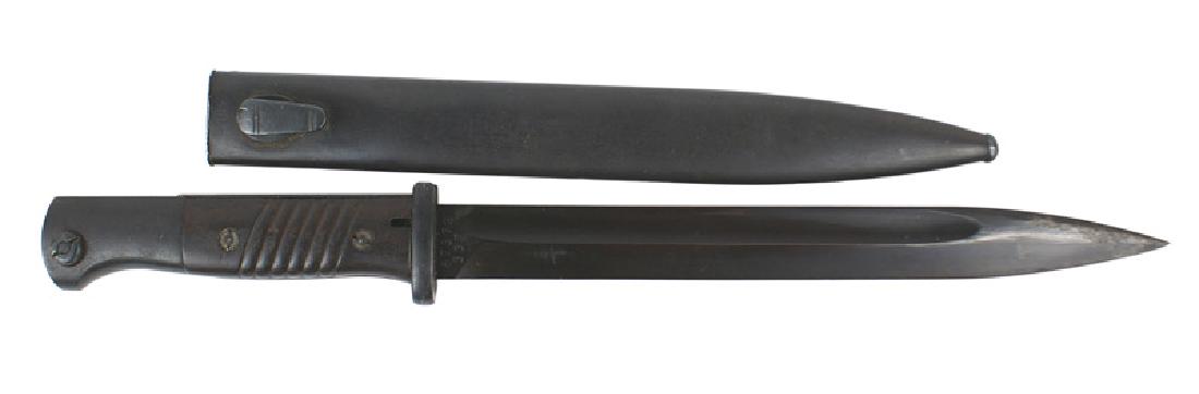 German WWII K-98 Mauser bayonet: D-042 German K-98 Mauser bayonet. Deep purple bakelite grips. Fittings and scabbard retain 98% of the original finish. 10" blued blade has some light pitting on the tip. Maker marked "bym" and numbere