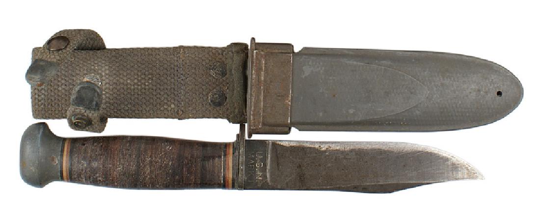 U.S. WWII Navy Mark 1 fighting knife: D-093 U.S. Navy WWII Mark 1 fighting knife. Darkened aluminum pommel and leather rings grip. With colored spacers at the top and bottom. Short crossguard. 5 1/4" parkerized blade. Edge has been sharpe