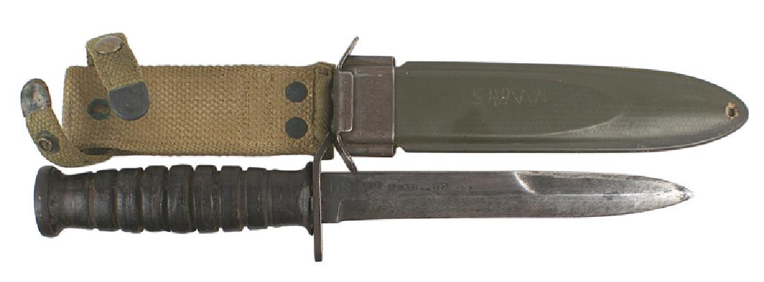 U.S. WWII M-3 combat knife: D-095 U.S. WWII M-3 combat knife. Parkerized flat pommel (flaming grenade stamping) and turned down crossguard. Leather rings grip. Well worn 6 1/2" gray blade marked "US M3 CAMILLUS". Fiber scabbard 