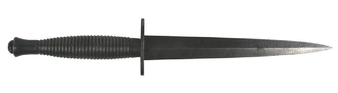 British WWII Fairbairn combat knife: D-122 British WWII Fairbairn combat knife. Type 2. Darkened ridged handle. Pommel is marked "1". Crossguard is stamped "ENGLAND". 6 3/4" blade retains 85% of the blued finish. No scabbard. II