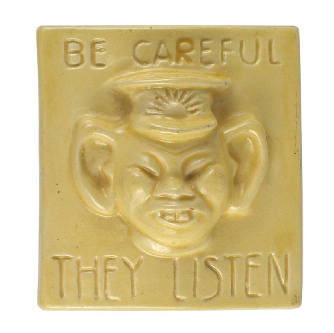 American made WWII Anti-Japanese tile: G-022 American made WWII Anti-Japanese propaganda tile. 4 3/4" x 4 1/2" glazed yellow ceramic panel bearing a high relief uncomplimentary portrait of a Japanese soldier. Americans were reminded to "BE