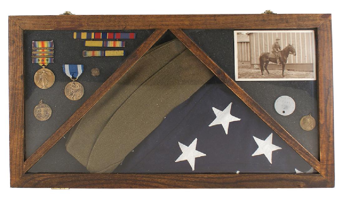 U.S. WWI veteran lot medals flag etc dog tag: S-051 Cased grouping related to U.S. WWI veteran John Scheffel of Rochester, NY. Includes: (1) Overseas hat. (2) "Dog tag" - named to above. (3) Photo postcard of above on horseback. Reverse is named 