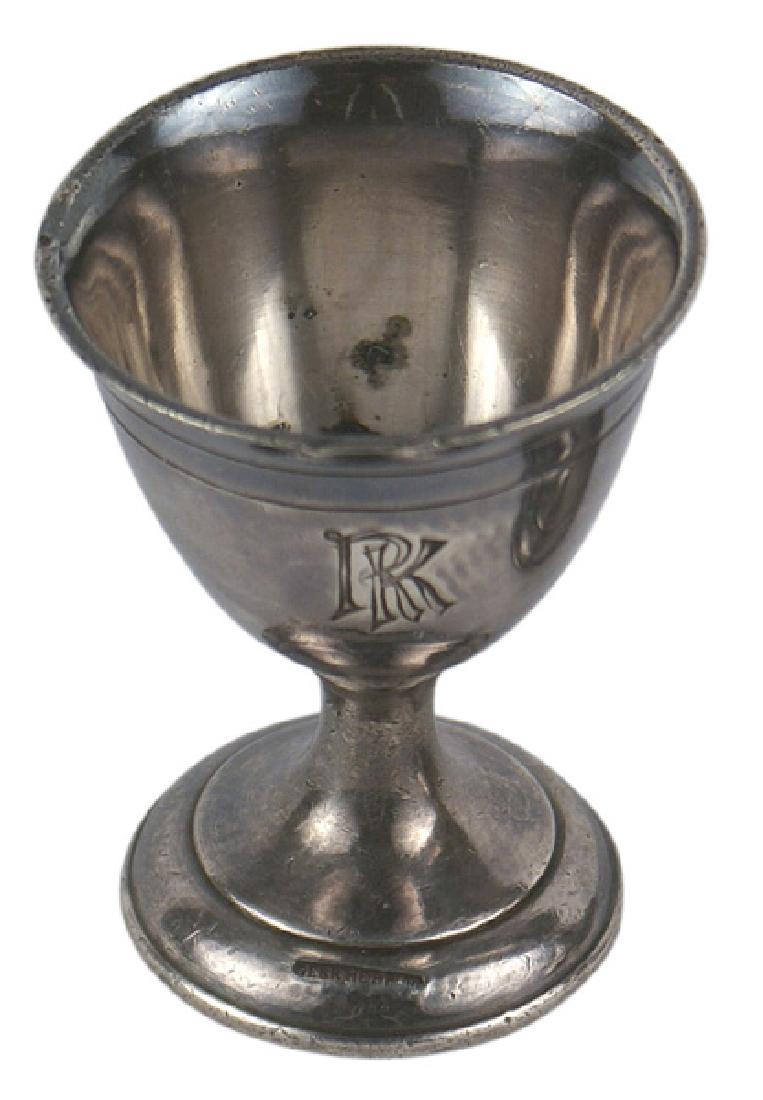 German WWII Reichschancellory egg cup Berchtesgaden: A-032 Reichschancellory - Berchtesgaden egg cup. Silvered metal 2 1/2" tall footed egg cup-engraved "RK". Base has a sunken cartouche "GEBR. HEPP 90". Top rim shows some expected wear. Purple patina.