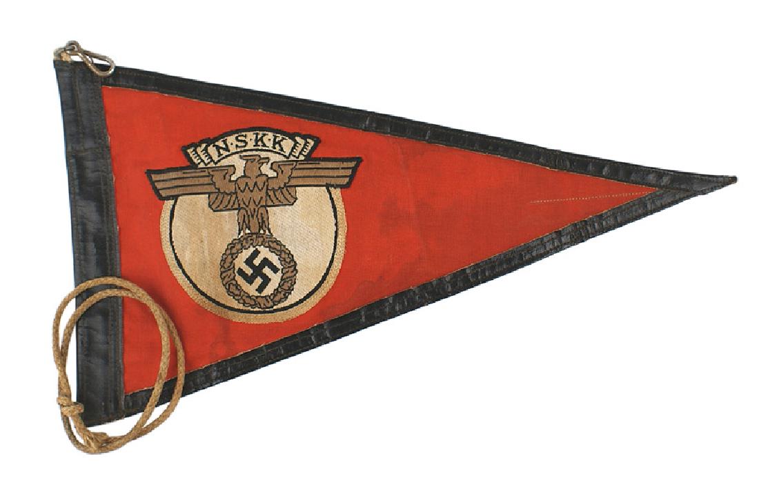 German WWII NSKK fender pennant: H-094 German WWII N.S.K.K. fender pennant. 6 3/4" x 12" black leather trimmed red triangular field bearing an embroidered eagle/swastika on a white roundel with a legend with "N.S.K.K.". Two-sided. Sn