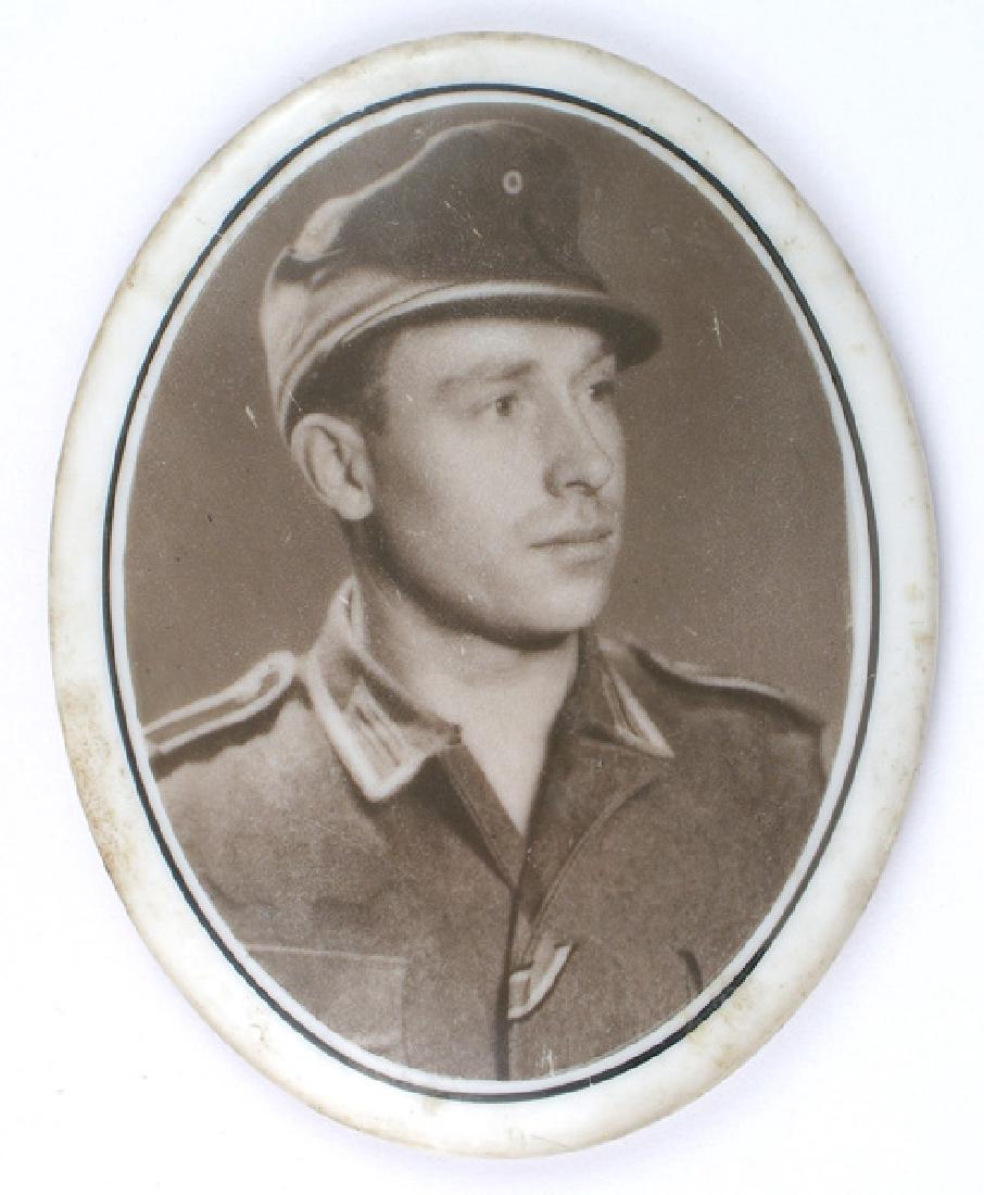 German WWII soldier photo porcelain: H-139 German WWII Soldier's photo on a 4" x 3 1/4" oval porcelain plaque to be mounted on a gravestone. Subject, an Army NCO is wearing an M43 cap. II