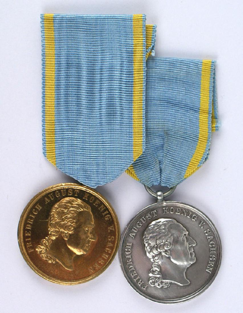 Saxony Lot of 2 Military Order Medal copies: H-233 Saxony. Lot of 2 Military Order of St. Henry. (1) Silver Medal. Bears profile of King Friedrich August. Reverse "FOR SERVICE TO THE FATHERLAND" with military motifs - all within a laurel leaf wr