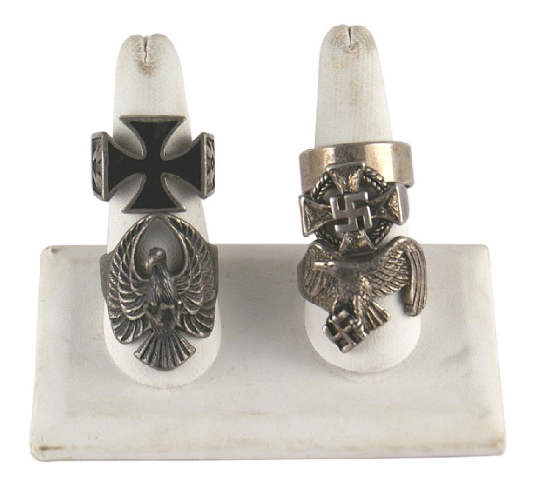 Lot of 4 post-war German WWII fantasy rings: H-240 Lot of 4 post-war fantasy rings: (1) Large eagle with swastika. (2) Loyalty Cross/swastika. (3) Iron Cross/SS runes. (4) Three-dimensional eagle. Also a wide wedding type ring. II