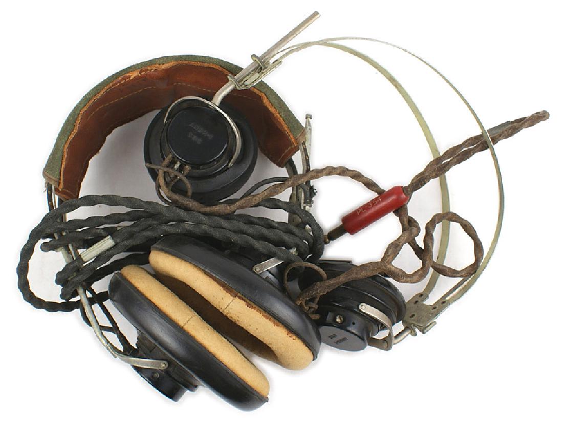 U.S. WWII earphones Army Air Force pilot: N-037 Lot of 2 sets of U.S. WWII earphones: (1) Army Air Force pilot. Large rubber covered padded ear pieces, OD canvass snap-on cover for a head band and wire with jack. (2) Radio operator's earphone