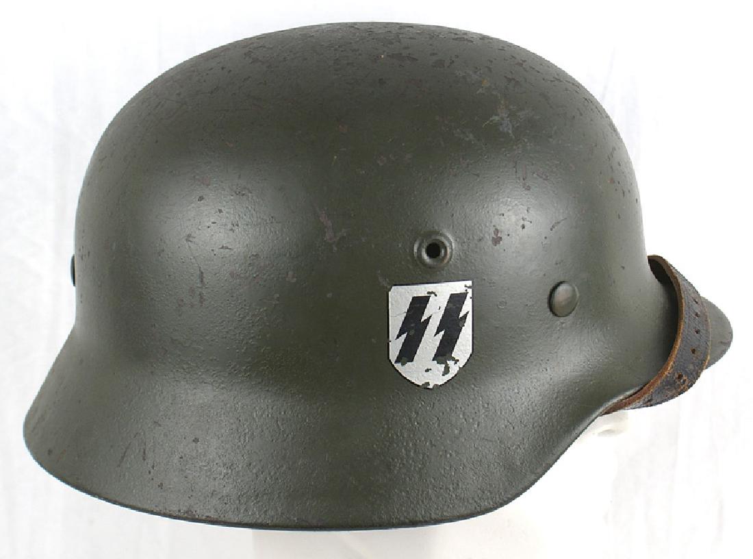 Fabricated German WWII Waffen SS helmet: E-027 Fabricated German Waffen-SS M1940 double decal helmet. 90% of the repainted finish remains. Reproduction decals - 95% SS runes decal and 95% swastika shield original leather chinstrap. Good cond
