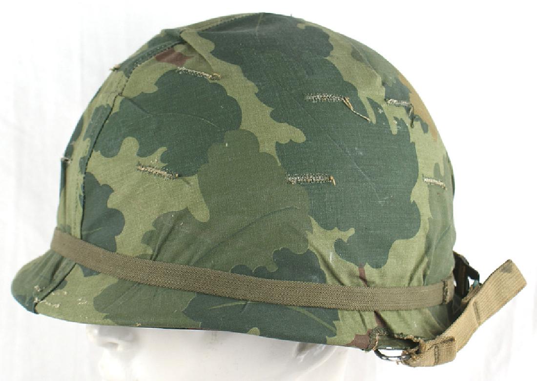 Lot 2 U.S. post WWII M1 helmet peaked cap: E-062 Lot of two: (1) U.S. post-WWII M-1 helmet. O.D. sand finish. Swivel bale. Camouflage cloth reversible cover. Smooth green finish plastic liner with the 98th Division and Captain's Bars decals an