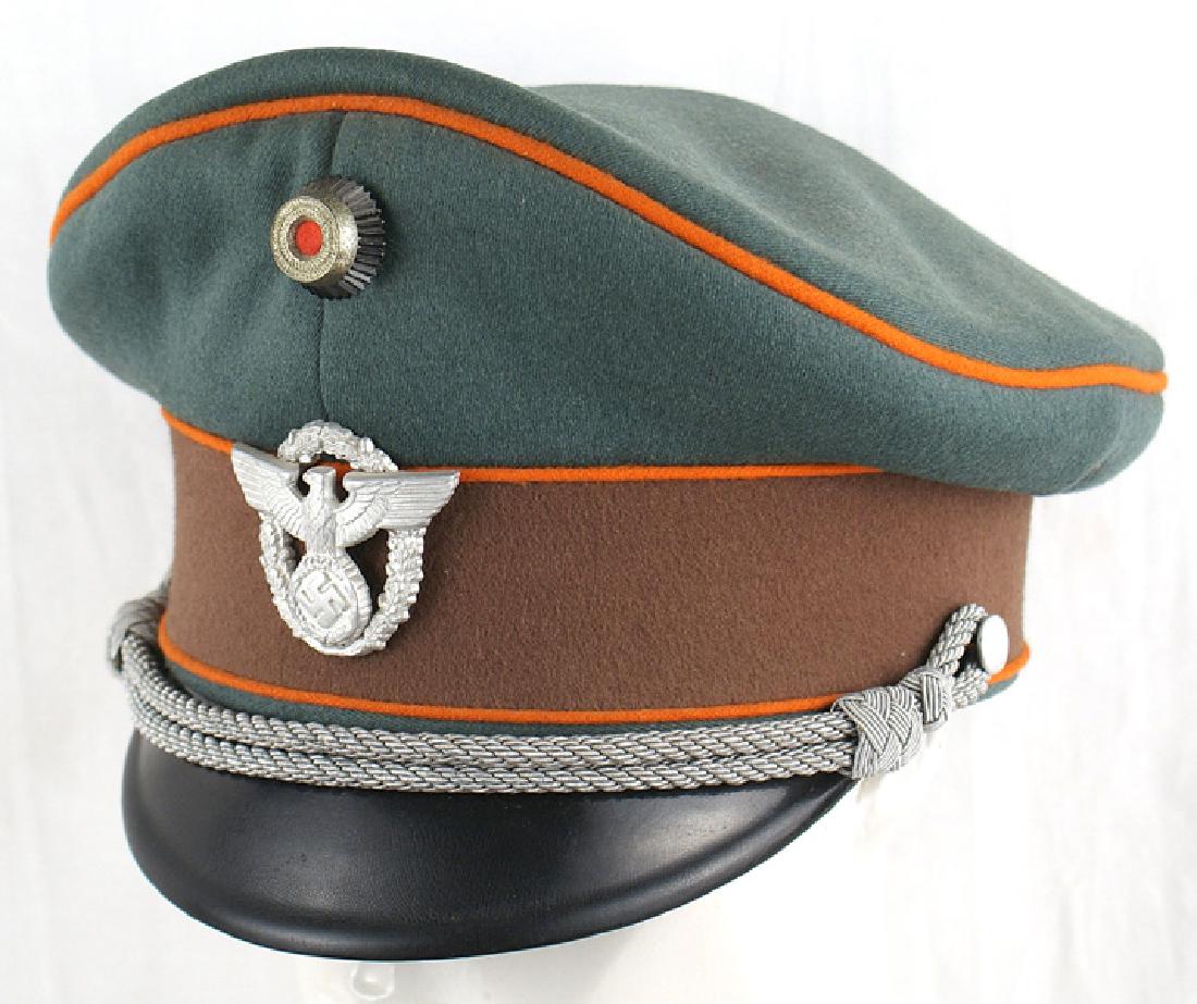German WWII Police Gendarmerie peaked cap: E-095 Police "Gendarmerie" officer's peaked cap. Nice "saddle shape" green body with an orange piped crown and brown band. High relief rosette and two-piece Police eagle/swastika mounted on a full wre