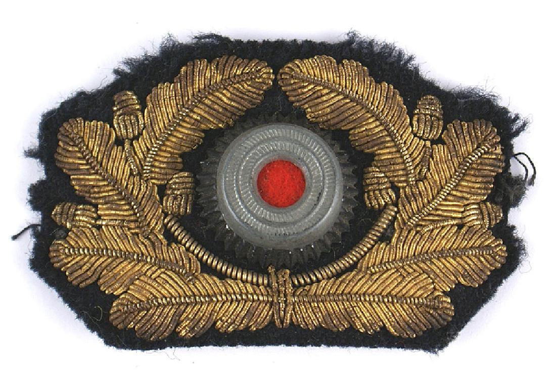 German Third-Reich Army General peaked cap insignia: E-189 German Third-Reich Army General's peaked cap insignia. Relief gold bullion wreath with a center metal rosette with a red felt insert. II