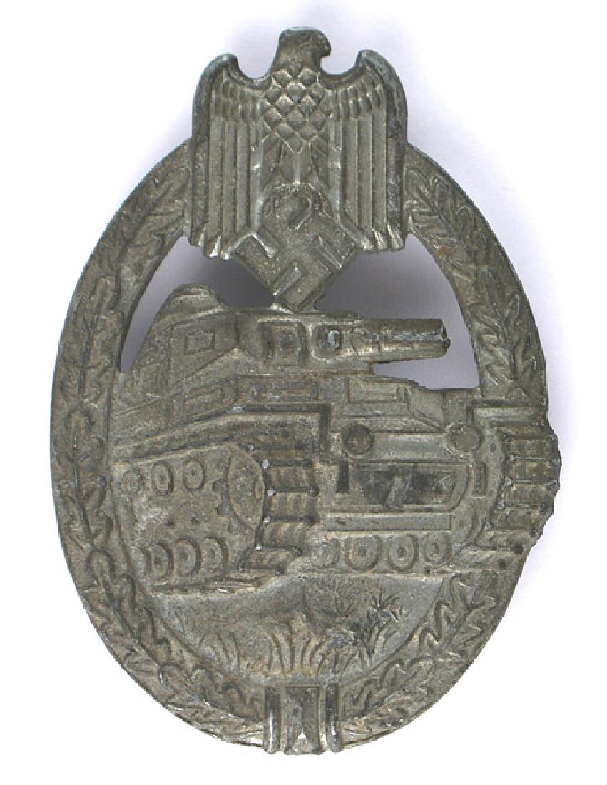 German WWII Panzer Assault Badge Silver: B-141 Panzer Badge - Silver. Solid type. Oak leaf wreath holding a forward moving Panzer. Armed Forces eagle/swastika at top. Traces of silver on eagle. Dished reverse. II