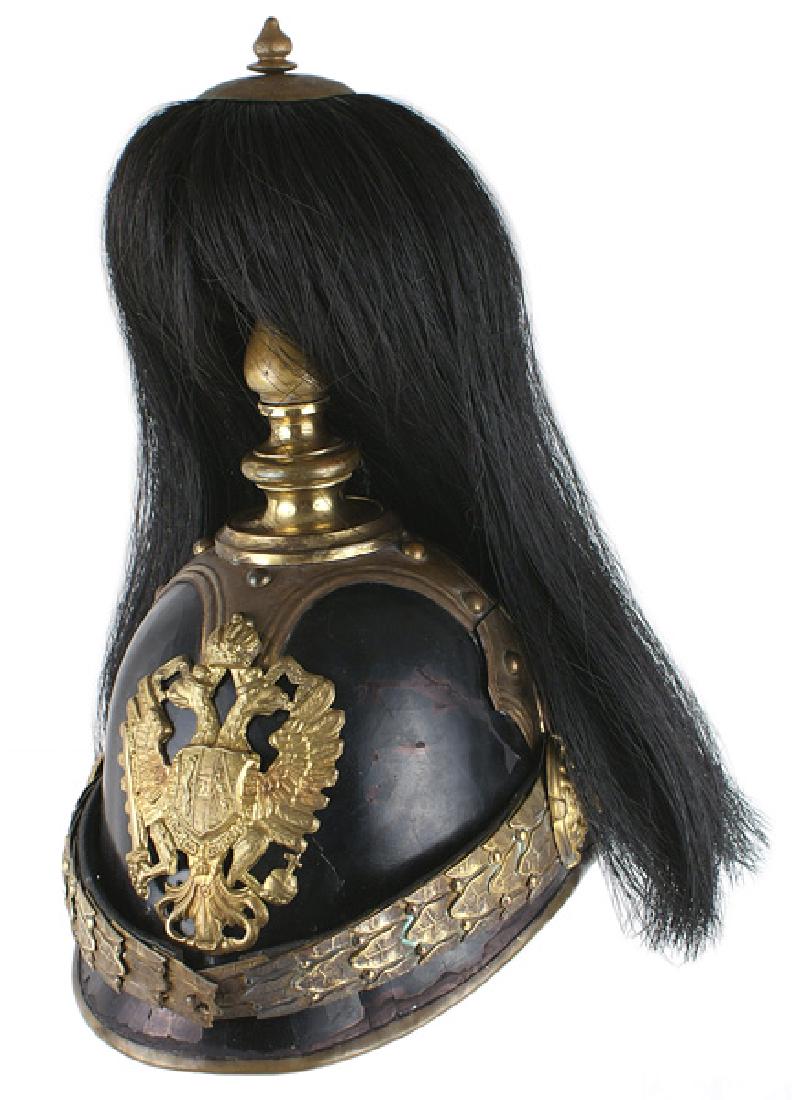 Imperial Austrian Garde officer helmet: E-001 Austrian Garde officer helmet, black leather body with gilt brass laurel leaf chinscales, lion head bosses, tiered spike base, extended cruciform base with domed studs on each strap and trim alo