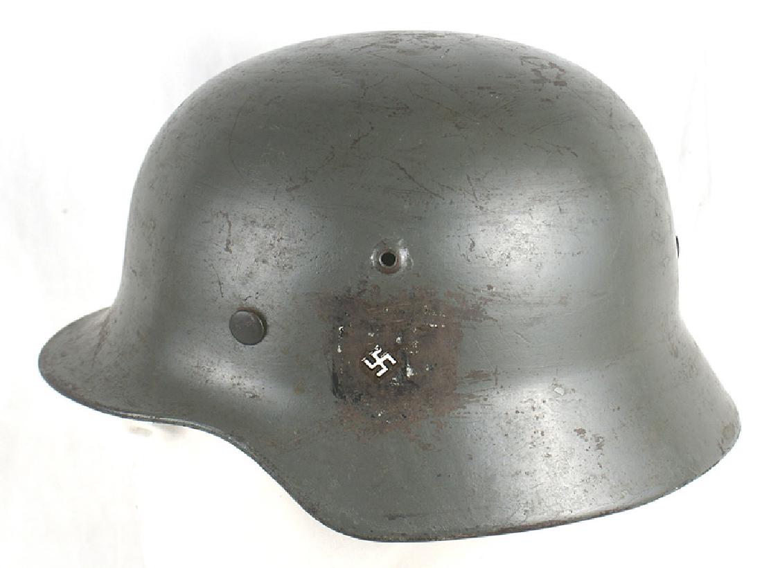 German WWII M1935 helmet: E-018 German M1935. Has an old gray repainted finish. Luftwaffe eagle decal was scratched away only leaving the swastika. National Colors shield was painted on when the finish was repainted. Shows som