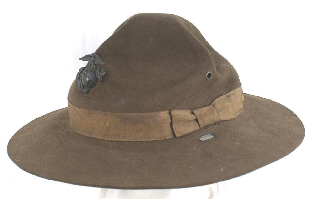 USMC WWII DI hat Marine Corps: E-085 U.S.M.C. WWII DI hat. Blackened EGA badge. Ribbon and cap are soiled and show some wear. Leather sweatband. Missing chinstrap. II-