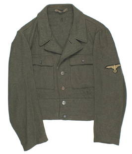 German WWII Waffen SS M1944 OD tunic: F-022 German WWII Waffen-SS M1944 ersatz type OD tunic. Waist length with two button down pockets. Machine sewn bevo type sleeve eagle. Collar tabs were removed - probably at the time of capture/or as