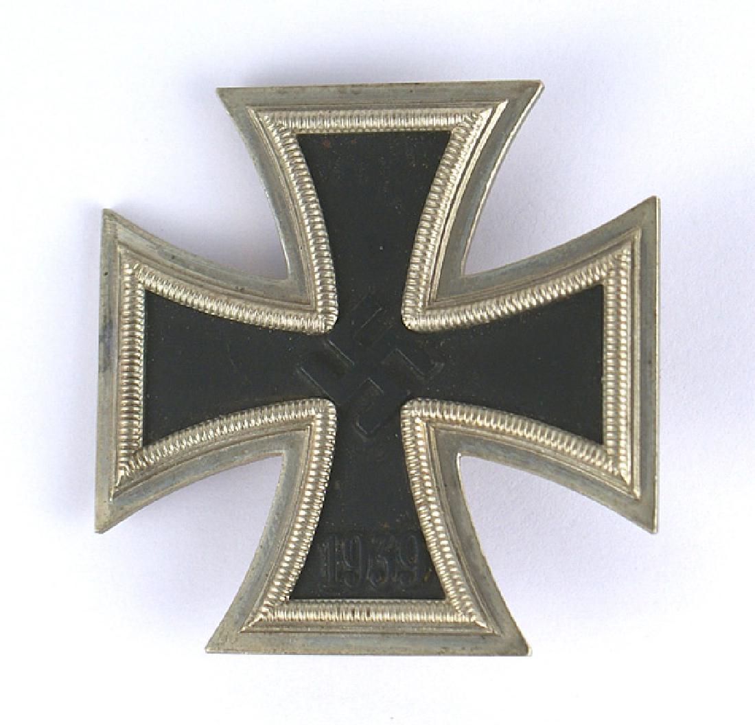 German WWII 1939 Iron Cross 1st Class: B-094 1939 Iron Cross 1st Class. Pin-back. Black center, relief swastika and age toned silver frame. Wide pin is marked "LII" (Grossmann & Co. in Vienna). II+