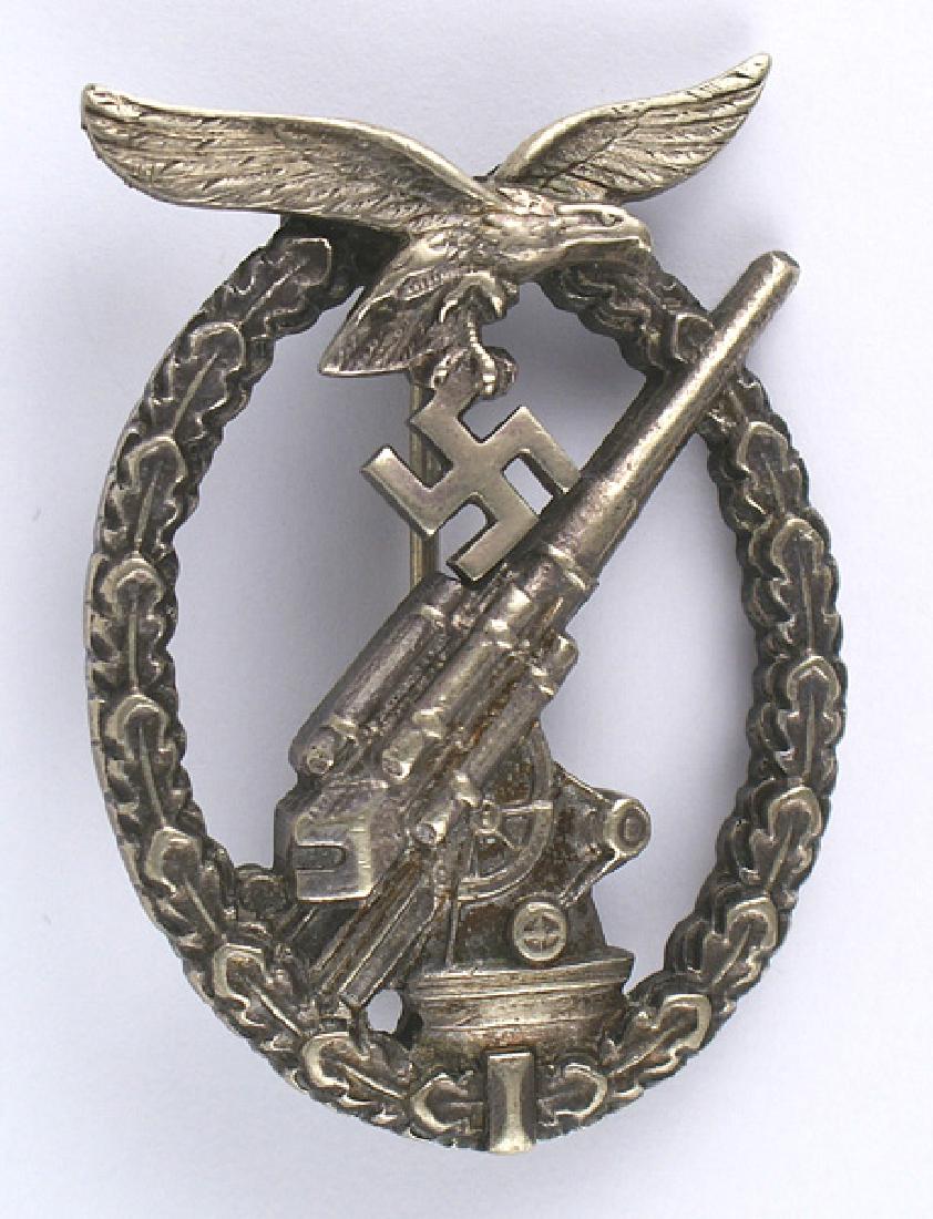 German WWII Luftwaffe Flak Badge: B-185 Luftwaffe Flak Badge. Age-toned large silver open oak leaf wreath with a separately mounted flying eagle/swastika at the top. The wreath holds a relief Flak 88 showing excellent detail. Age dark