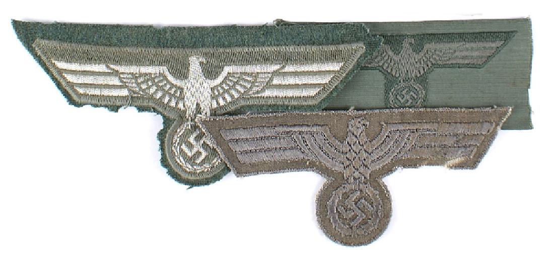 Lot of German WWII Army eagles: H-049 Lot of Army eagles: (1) Flat silver wire type. Was machine sewn to OD backing. (2) Wartime breast eagle. Silver-gray on a gray type backing. (3) Army bevo-embroidered eagle for the M43 and o'sea
