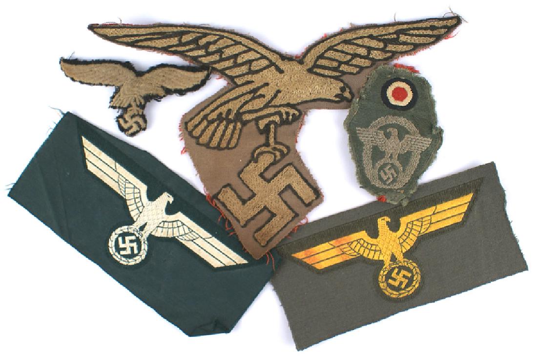 Lot of German WWII embroidered eagle insignia: H-050 Lot of Third-Reich embroidered insignia: (1) Uncut Army and Navy bevo type breast eagles. (2) Luft. "Hermann Goring" o'seas cap eagle (black backing) - removed from a cap. (3) Police bevo rosett