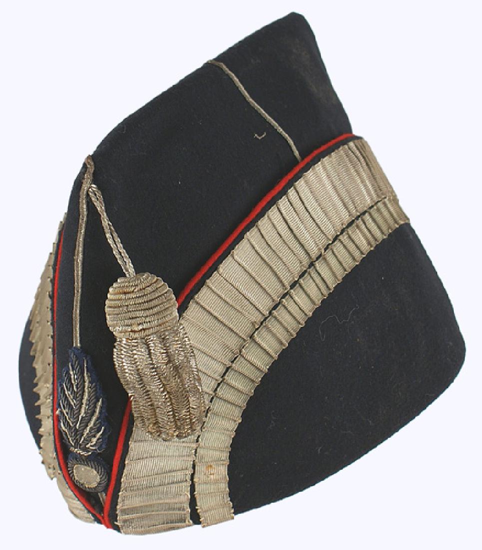 Lot of 2 French M1860 Belgian Police caps: E-003 Lot of 2 military caps: (1) French Model 1860 Second Empire dress cap. High type in a fine black fabric with red piped turned up sides. Two rows of "pinched" silver bullion "tape" form an arc on