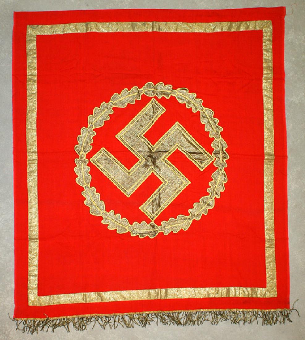 German WWII NSDAP rostrum banner flag: H-047 N.S.D.A.P. high ranking political leader's rostrum banner. Tilted 16" flat gilt wire swastika outlined in gold cord. Mounted inside of a "Cut-out" flat gold wire oak leaf wreath. Red field backg