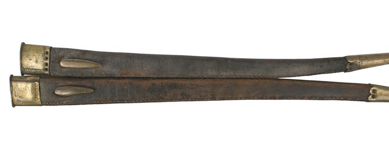 Two British M1853 Enfield bayonet scabbards: D-065 Lot of 2 scabbards for the British M1853 early type Enfield 17" bayonet. Seam sewn on the side of the black leather body. One is marked "QOR-132". 1 1/2" brass throat and 3" tip. Brass hook on r