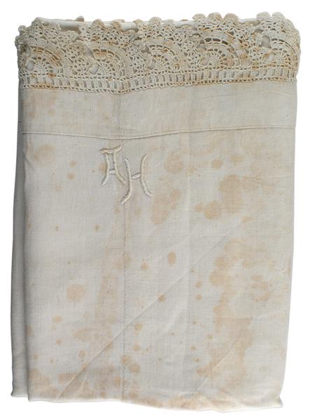 Adolf Hitler personal linen bed sheet: A-029 Adolf Hitler linen bed sheet. Off-white has aged and shows foxing. 2" open lace border. High relief embroidered "AH". 61" x 100". An early type. (The style of the lettering is similar to the AH 